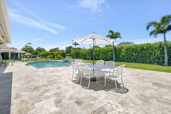 a view of a patio with a table and chairs under an umbrella