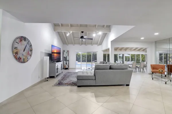 a living room with furniture a flat screen tv and a large window