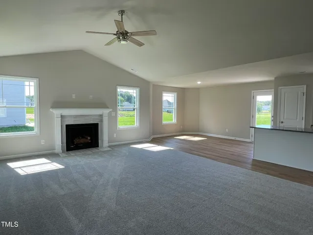 an empty room with windows and fireplace