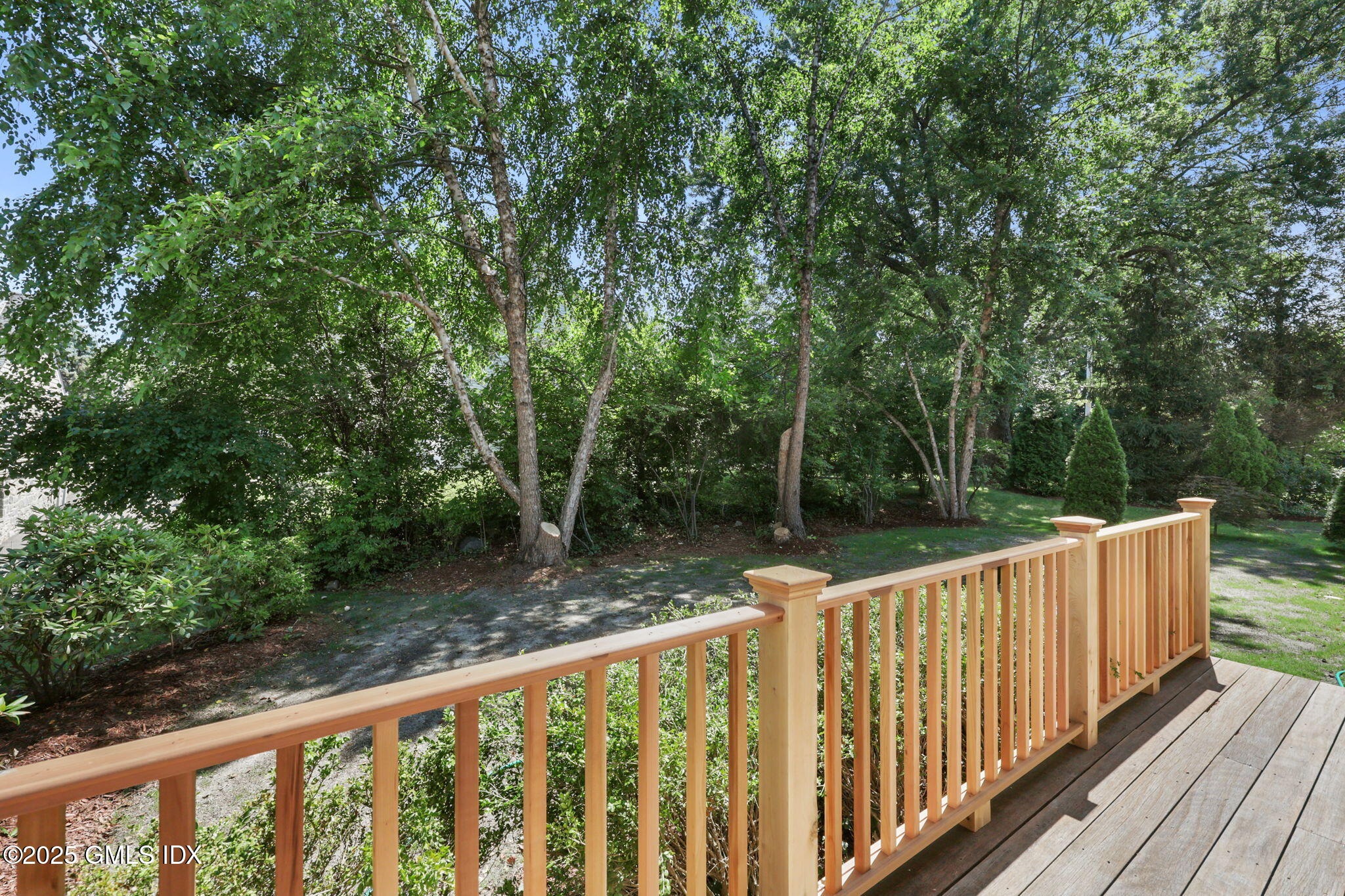 263 Byram Road Greenwich, CT 06830 - Photo 28 of 32 a view of deck and trees with wooden fence