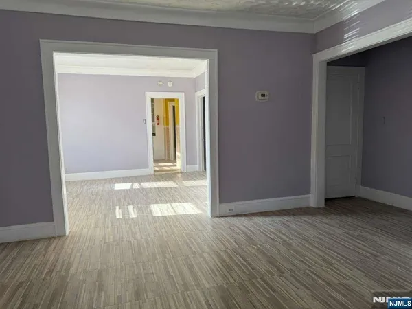 a view of a room with wooden floor and a window