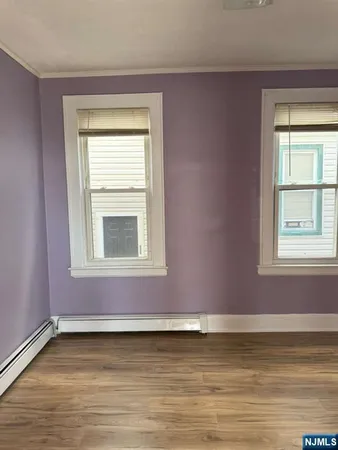 a view of a room with wooden floor and a window