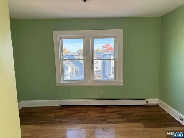 a view of a room with wooden floor and a window
