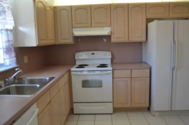 a kitchen with a stove and white cabinets