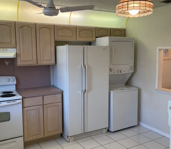 a kitchen with cabinets and a refrigerator