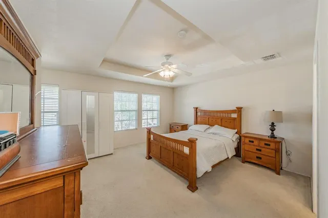 a spacious bedroom with a bed and large windows