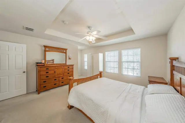 a bedroom with a bed a dresser and a window