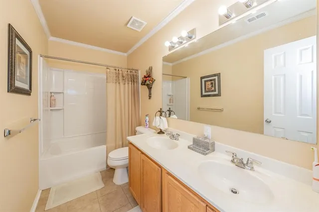 a bathroom with a double vanity sink toilet and shower