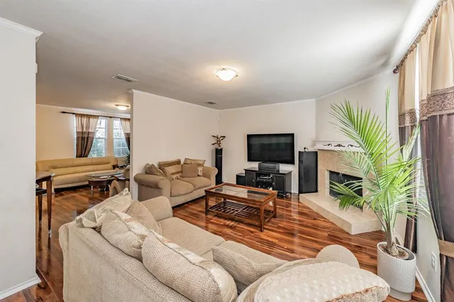 a living room with furniture a flat screen tv and a fireplace