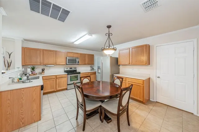 a kitchen with a dining table chairs and white cabinets
