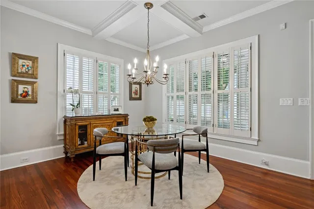 a dining room with furniture a chandelier and wooden floor