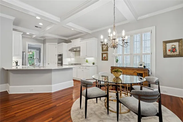 a dining room with furniture a chandelier and wooden floor