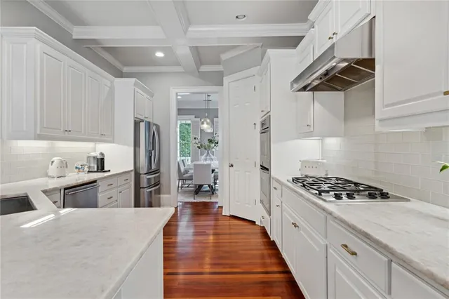a kitchen with granite countertop a sink stove and refrigerator