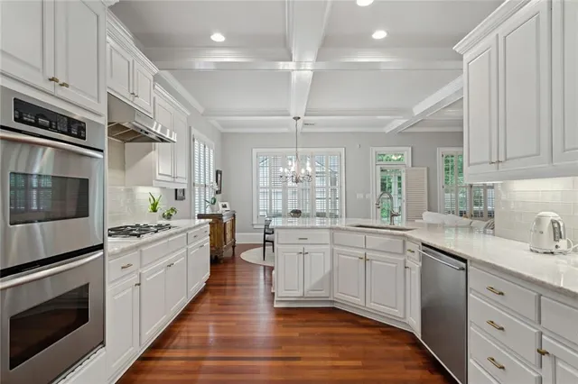 a large kitchen with stainless steel appliances granite countertop a stove sink and cabinets
