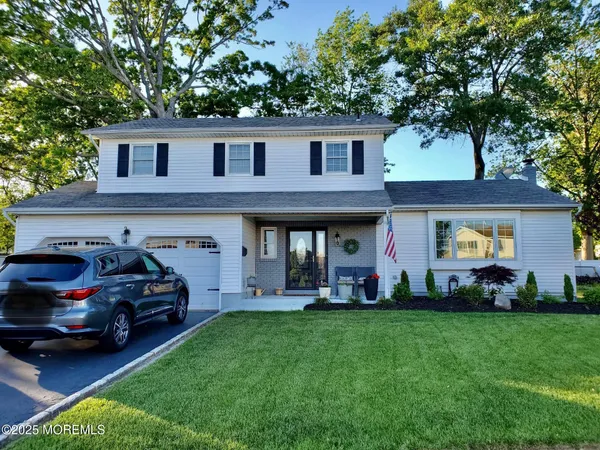 a car parked in front of a house with a yard