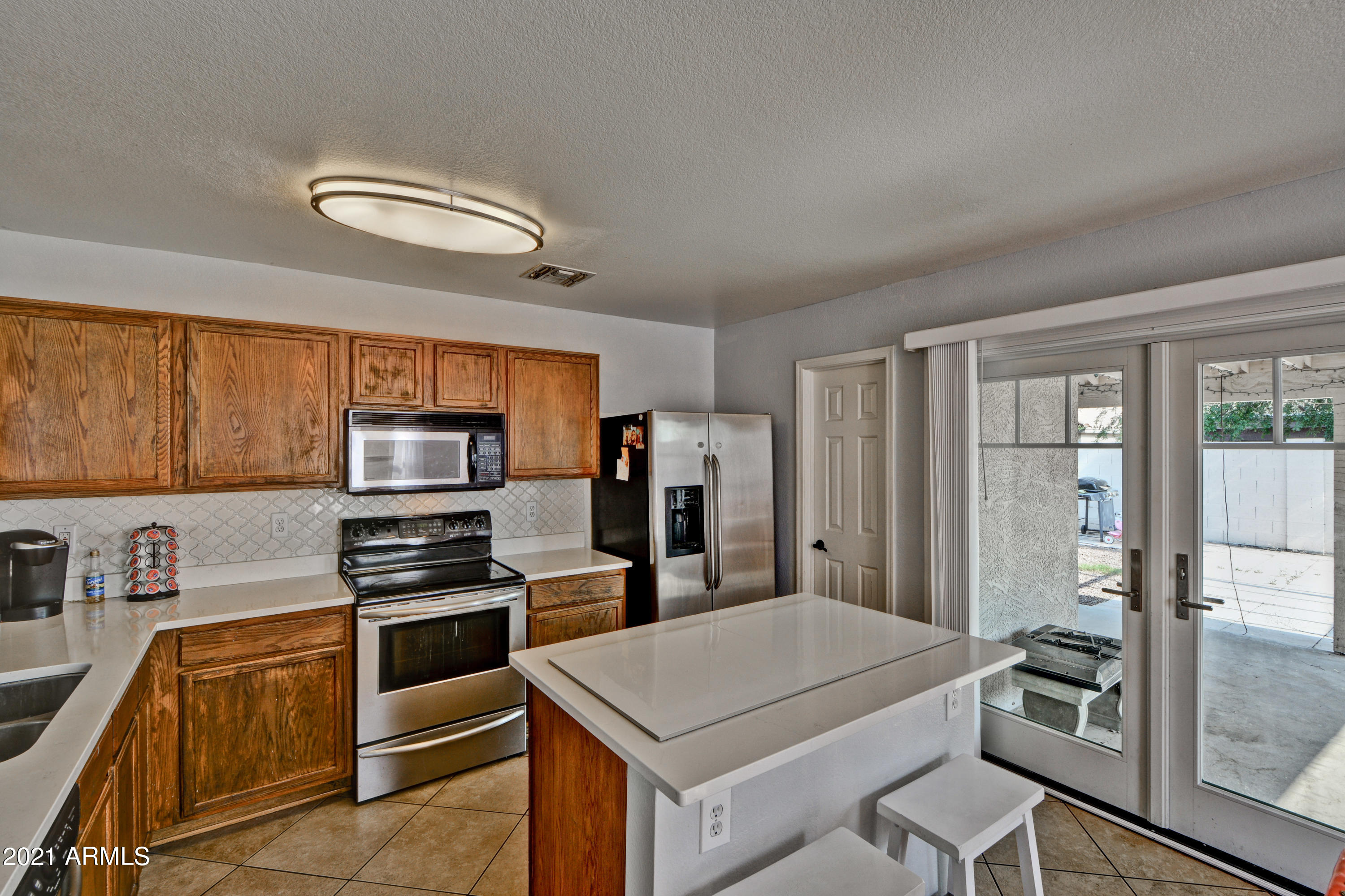 7945 West Hatcher Road Peoria, AZ 85345 - Photo 5 of 15 a kitchen that has a sink stainless steel appliances and cabinets