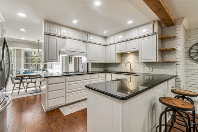 a kitchen with granite countertop a sink a counter top space and stainless steel appliances
