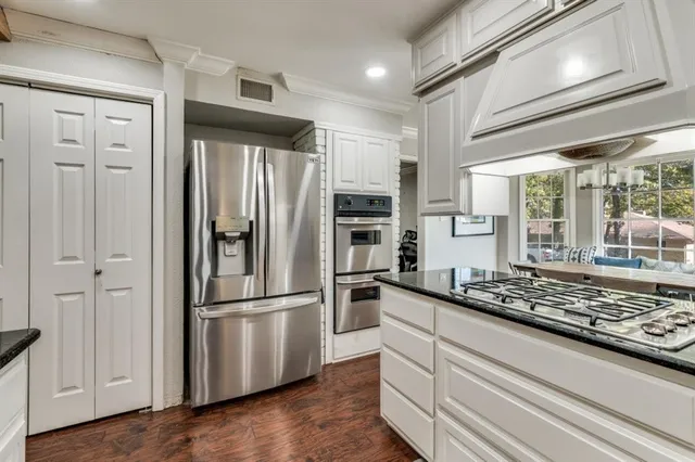 a kitchen with stainless steel appliances granite countertop a refrigerator and a sink
