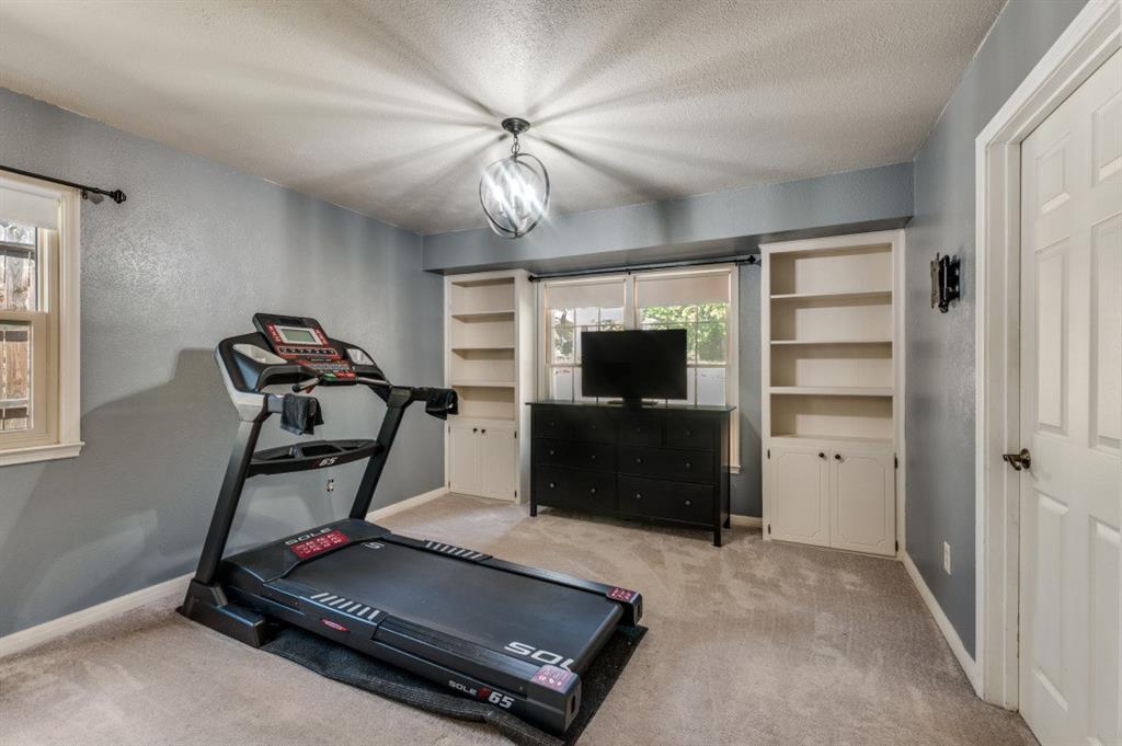 7544 Madeira Drive Fort Worth, TX 76112 - Photo 15 of 25 a room with gym equipment and a flat screen tv