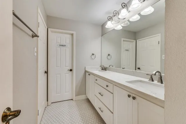a bathroom with a double vanity sink and a mirror with shower