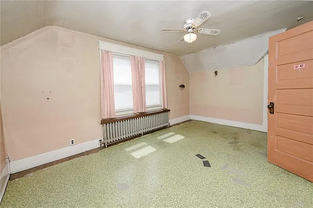 an empty room with windows and ceiling fan