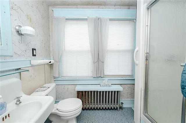 a bathroom with a sink a toilet and a mirror