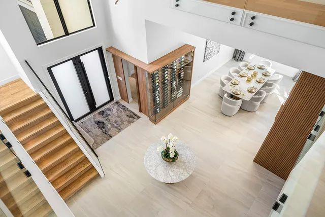 a bedroom with a bed a mirror and potted plant on dresser