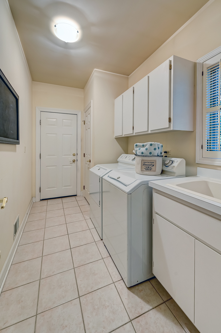 3 Berkshire Lane Burr Ridge, IL 60527 - Photo 19 of 40 a utility room with cabinets washer and dryer