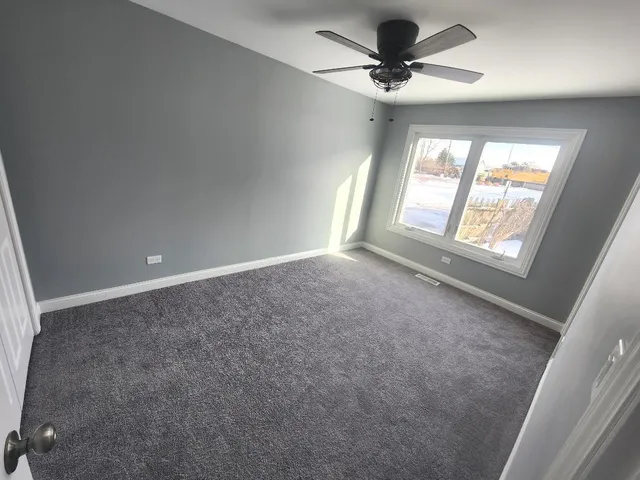 a view of a livingroom with a ceiling fan and window