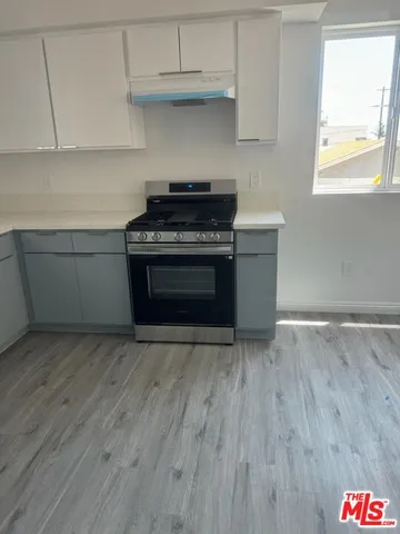 a kitchen with granite countertop a stove and a wooden floors