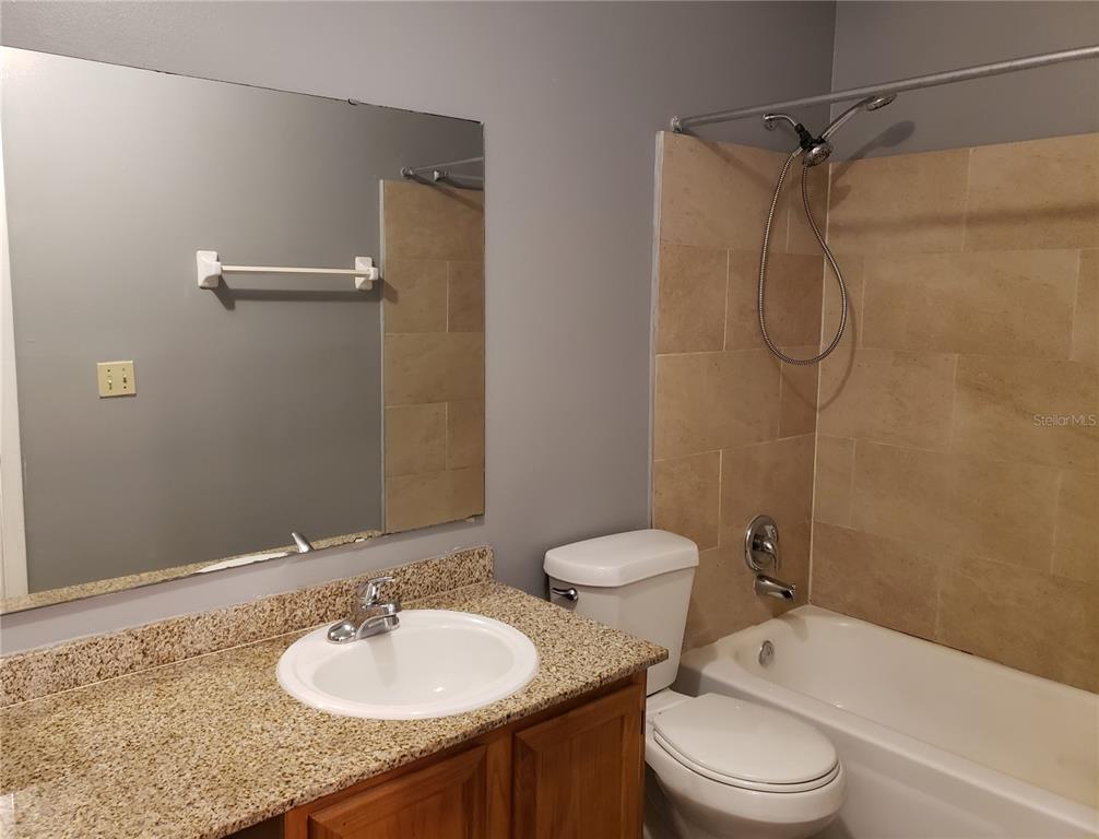 4151 South Semoran Boulevard, Unit 8 Orlando, FL 32822 - Photo 12 of 27 a bathroom with a granite countertop sink toilet and shower