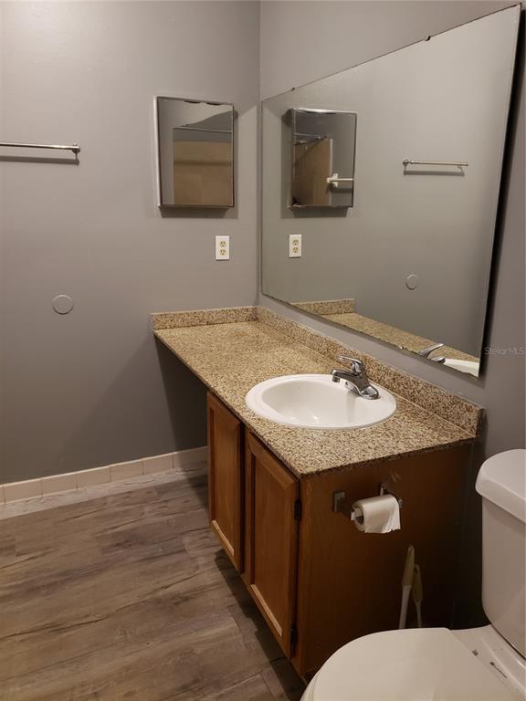 4151 South Semoran Boulevard, Unit 8 Orlando, FL 32822 - Photo 14 of 27 a bathroom with a granite countertop sink and a toilet
