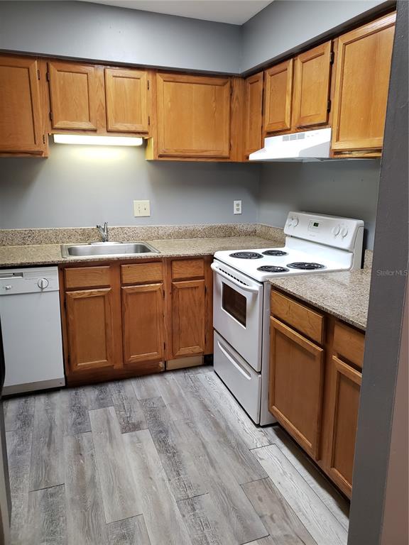 4151 South Semoran Boulevard, Unit 8 Orlando, FL 32822 - Photo 6 of 27 a kitchen with granite countertop cabinets stainless steel appliances and a sink