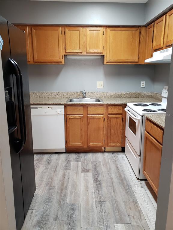 4151 South Semoran Boulevard, Unit 8 Orlando, FL 32822 - Photo 7 of 27 a kitchen with granite countertop stainless steel appliances a sink window and cabinets