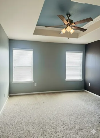 an empty room with a window and a ceiling fan