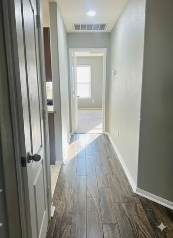 a view of a hallway with wooden floor