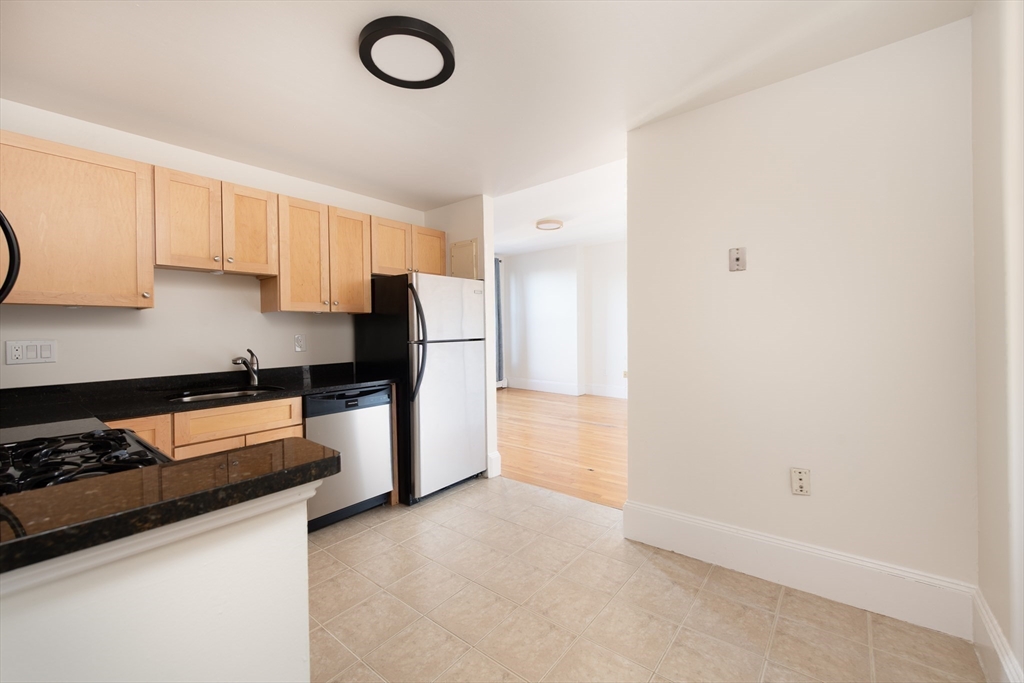 362 Commonwealth Avenue, Unit 4E Boston, MA 02115 - Photo 14 of 19 a kitchen with stainless steel appliances a refrigerator a stove a sink and white cabinets