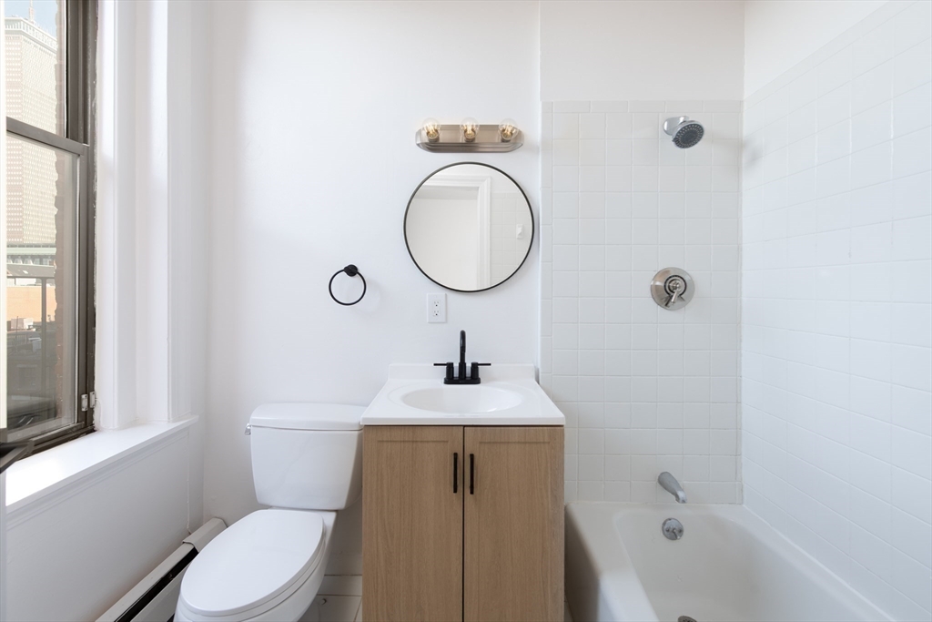 362 Commonwealth Avenue, Unit 4E Boston, MA 02115 - Photo 18 of 19 a bathroom with a toilet a sink a mirror and a window