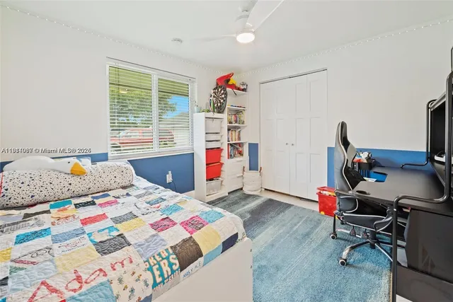 a bedroom with a bed a desk and a chandelier