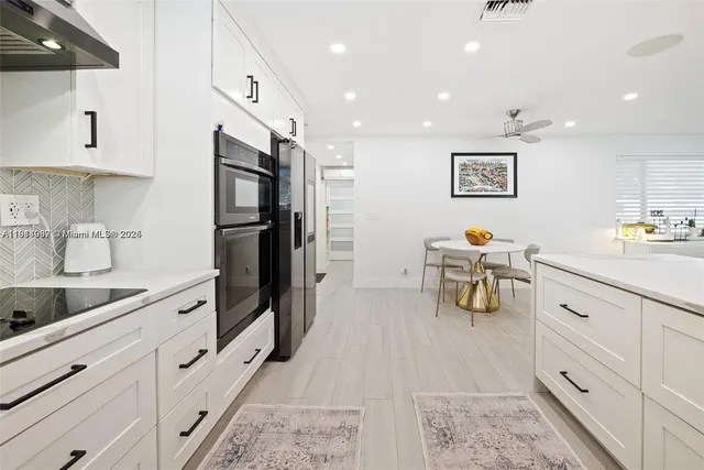 a kitchen with granite countertop a refrigerator and cabinets