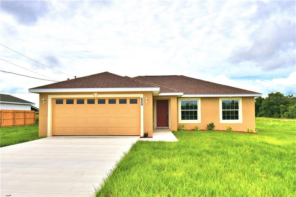 a front view of a house with a garden and yard