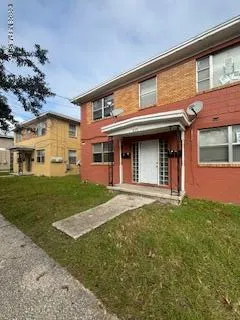 front view of a brick house with a yard