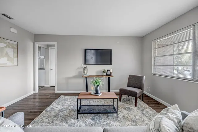 a living room with furniture and wooden floor