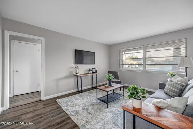 a living room with furniture and wooden floor