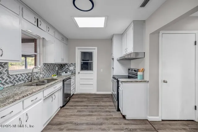 a kitchen with granite countertop white cabinets and white appliances