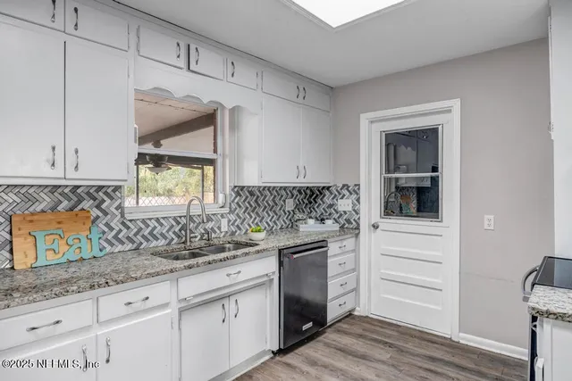 a kitchen with white cabinets and stainless steel appliances