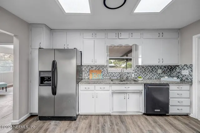 a kitchen with stainless steel appliances granite countertop a dining table chairs and granite counter tops