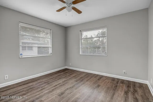 a view of an empty room with wooden floor