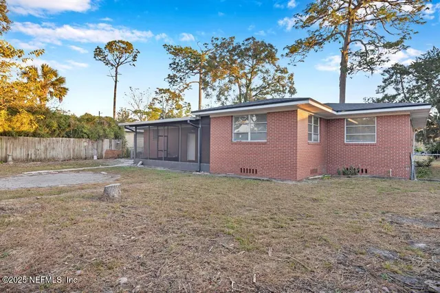 a view of a yard with large tree and wooden fence
