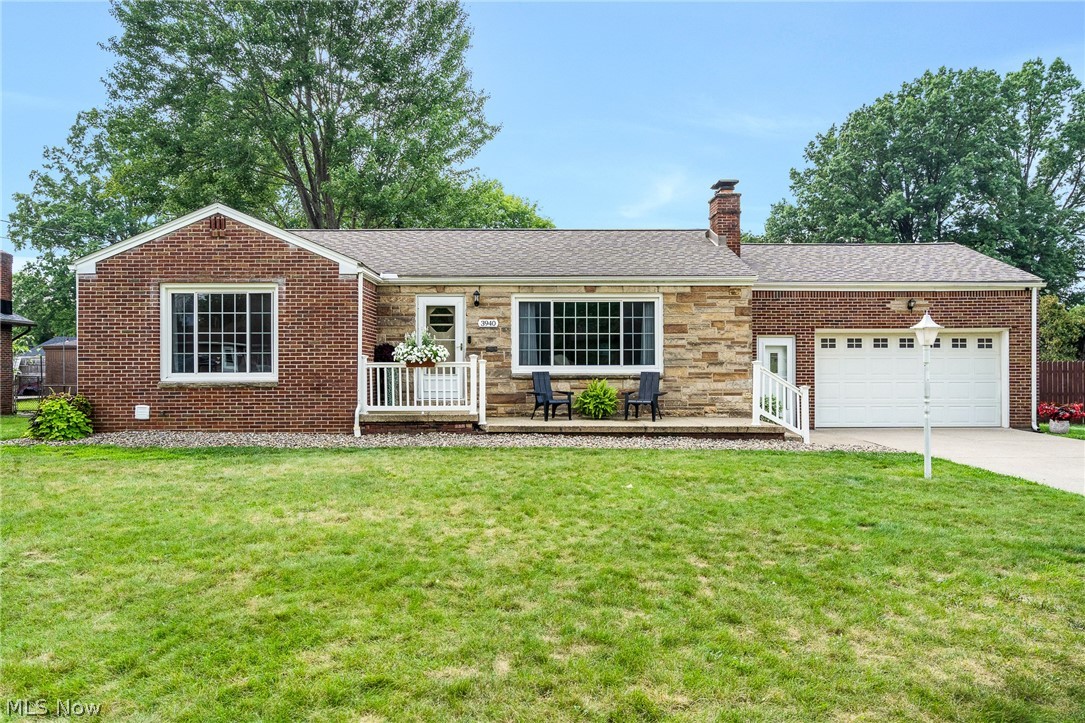3940 Shelby Road Youngstown, OH 44511 - Photo 1 of 20 Brick and stone exterior with a covered porch, white railing, and an attached garage